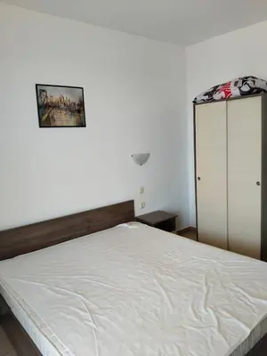 a bedroom with a white bed and a cabinet at 2 Room Apartment Costa Calma Aheloy Bulgarien in Aheloy