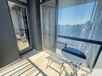 a chair sitting on the balcony of a building at Valentina Apartment in Burgas City