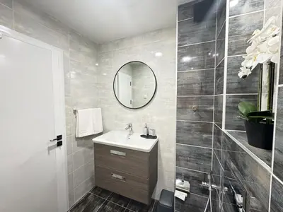 a bathroom with a sink and a mirror at Valentina Apartment in Burgas City