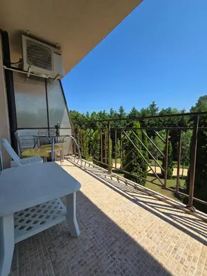 a patio with a white table and chairs on a balcony at Orchid Fort Garden in Sunny Beach