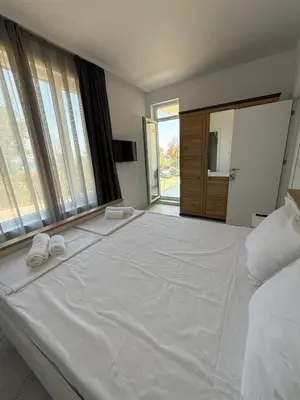 a large white bed with two white towels on it at Aurum Villas Smokinya Beach 2 in Sozopol