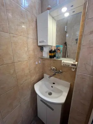 a small bathroom with a sink and a mirror at Studio Vili 2 in Varna City