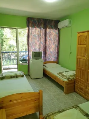 a bedroom with two beds and a television in it at Hotel Maria in Kiten