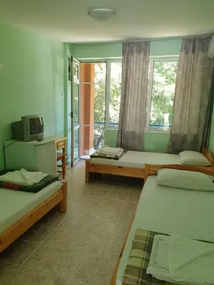 a room with two beds and a television in it at Hotel Maria in Kiten