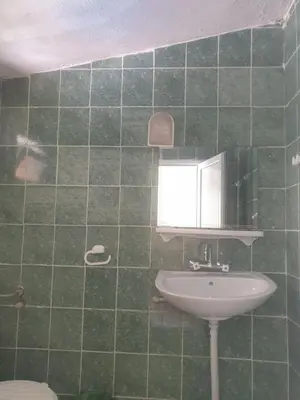 a green tiled bathroom with a sink and a window at Hotel Maria in Kiten