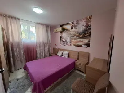 a bedroom with a purple bed and a painting on the wall at Sunset Complex Кошарица Апартамент 15 in Kosharitsa
