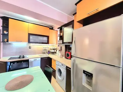 a kitchen with a stainless steel refrigerator and a table at Aquapark 2BD Apartment for Family in Sunny Beach