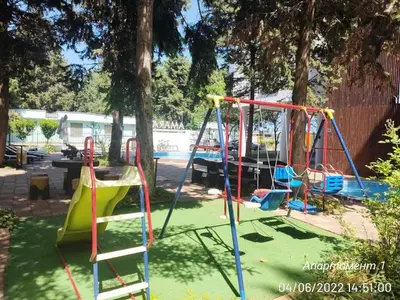 a playground with a slide and swings at Blue Beach Apartments - Amara in Ravda