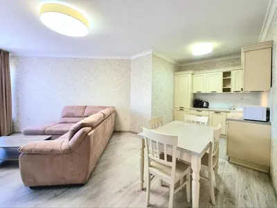 a living room with a couch and a table and a kitchen at Sunrise Dreams Apartment with free Parking in Burgas City
