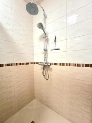 a shower in a bathroom with wooden tiles at Sunrise Dreams Apartment with free Parking in Burgas City