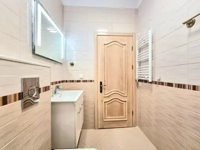 a bathroom with a wooden door and a sink at Sunrise Dreams Apartment with free Parking in Burgas City