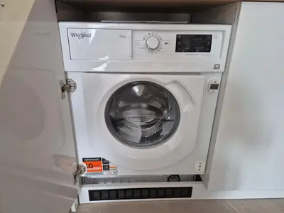 a washer and dryer in a white cabinet at Verano Deluxe Studios in Burgas City
