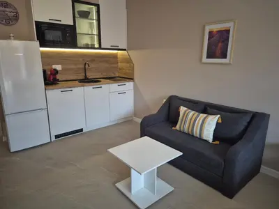 a living room with a couch and a table at Verano Deluxe Studios in Burgas City