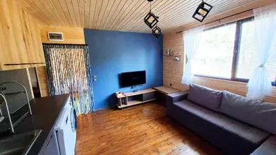 a living room with a couch and a tv at Еко Къщи Градина in Sozopol