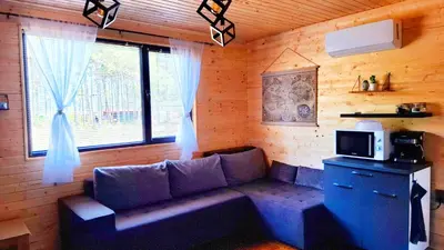 a living room with a couch and a window at Еко Къщи Градина in Sozopol