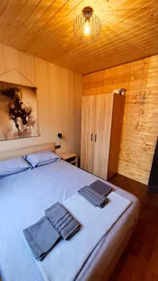 a bedroom with a bed with towels on it at Еко Къщи Градина in Sozopol