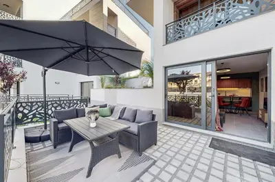 a patio with a table and chairs and an umbrella at BellaViaStay, Flat Thalassa 1BD in Sozopol