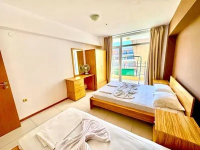 a hotel room with two beds and a window at Apartcomplex Grand Kamelia Sunny Beach in Sunny Beach