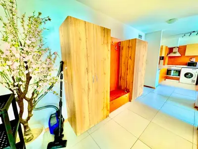 a kitchen with wooden doors and a tree in a room at Apartcomplex Grand Kamelia Sunny Beach in Sunny Beach