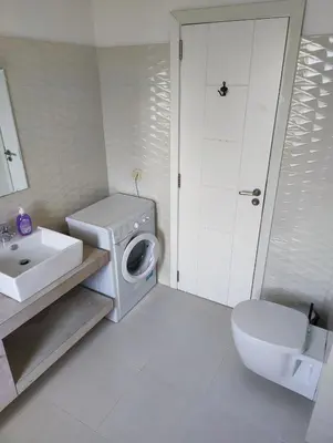 a bathroom with a washing machine and a sink at Villa Casablanca with private pool in Lozenets