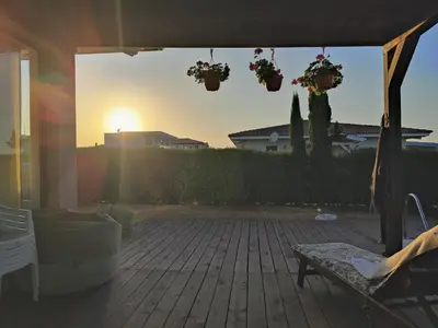 a patio with potted plants and the sun setting at Villa Casablanca with private pool in Lozenets
