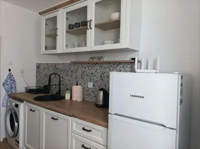 a kitchen with white cabinets and a white refrigerator at Sunrise home in Burgas City