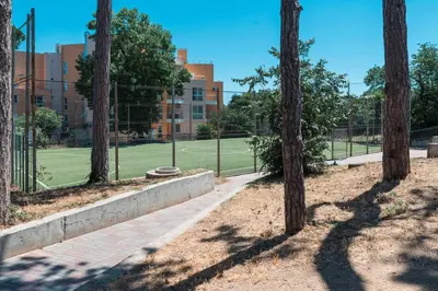 a tennis court with trees in front of a building at Galata Relax in Varna City
