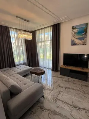 a living room with a couch and a television at Aurum Villas Smokinya Beach 3 in Sozopol