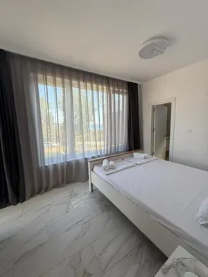 a large bed in a room with a large window at Aurum Villas Smokinya Beach 3 in Sozopol