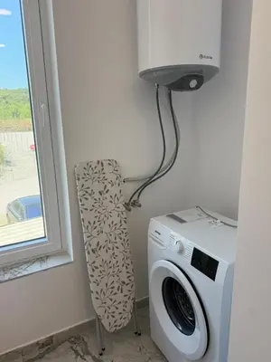 a washing machine and a chair in a room at Aurum Villas Smokinya Beach 3 in Sozopol