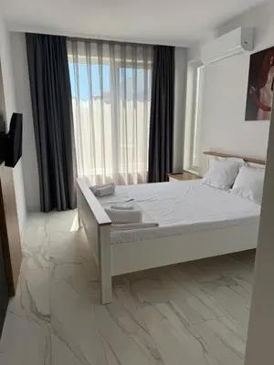 a white bedroom with a large bed and a window at Aurum Villas Smokinya Beach 3 in Sozopol