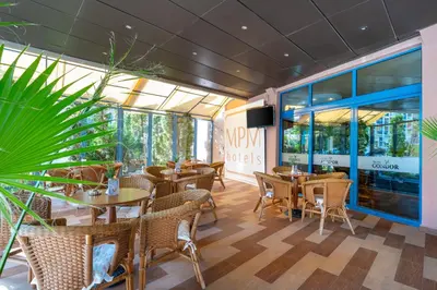 a restaurant with tables and chairs and windows at MPM Hotel Condor - All Inclusive Light in Sunny Beach