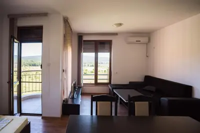 a living room with a couch and a table with chairs at Guest House Georgievi in Primorsko