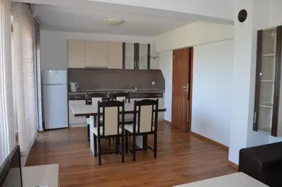 a kitchen and dining room with a table and chairs at Guest House Georgievi in Primorsko