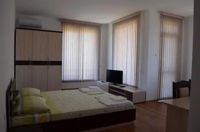 a bedroom with a bed and a television in it at Guest House Georgievi in Primorsko