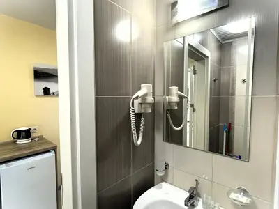a bathroom with a phone on the wall next to a toilet at Apart-Hotel Panorama Sea LUX in Primorsko