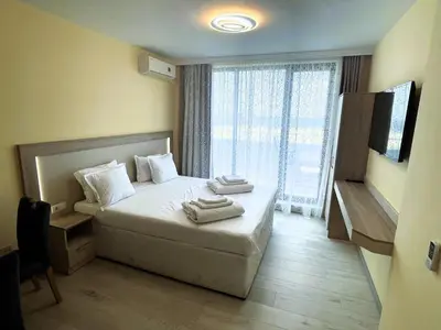 a bedroom with a bed with two towels on it at Apart-Hotel Panorama Sea LUX in Primorsko