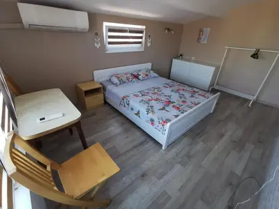 a small bedroom with a bed and a table at Апартамент Хармония ТОП Център в Стария Град in Pomorie