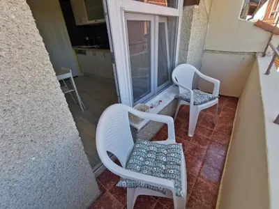 a couple of chairs sitting on a balcony at Апартамент Хармония ТОП Център в Стария Град in Pomorie
