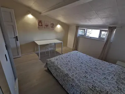 a bedroom with a bed and a table and a window at Апартамент Хармония ТОП Център в Стария Град in Pomorie