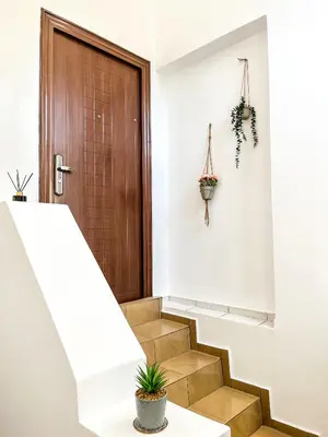 a hallway with stairs with a door and a potted plant at Centrino in Burgas City
