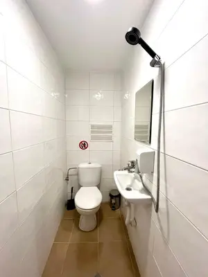 a white bathroom with a toilet and a sink at Centrino in Burgas City