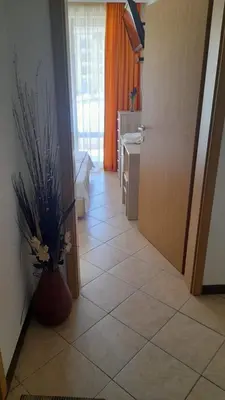 a hallway with a vase of flowers on a tile floor at 2 Room Apartment Royal Sun E24 with Poolview and big Balcony in Sunny Beach