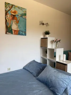 a bedroom with a bed and a painting on the wall at Sarafovo Sea and Airport Stay in Burgas City