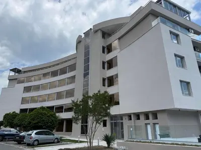 a white building with cars parked in front of it at TROPIC BEACH apart in Sunny Beach
