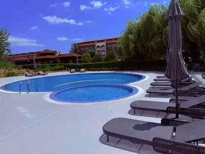 a swimming pool with lounge chairs and a umbrella at TROPIC BEACH apart in Sunny Beach