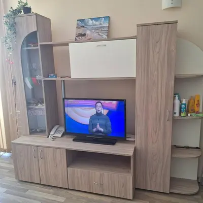 a tv in a wooden entertainment center with a television at Panoramic sea view at the beach in Obzor