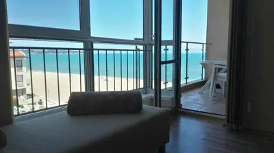 a room with a view of the beach from a balcony at Panoramic sea view at the beach in Obzor