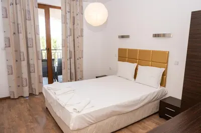 a bedroom with a large bed with white sheets at Paradise View Guest Apartment in Sozopol