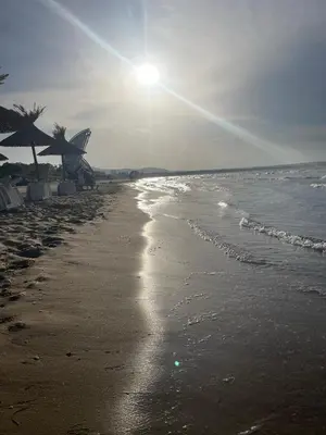 a beach with the sun shining on the water at Family Paradise in Laguna Beach Hotel in Sozopol